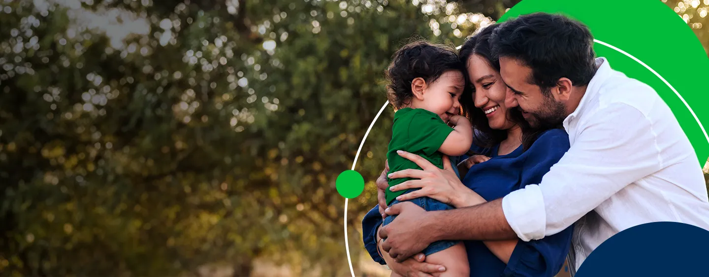 Família feliz abraçando uma criança em um ambiente ao ar livre, transmitindo amor e conexão familiar.