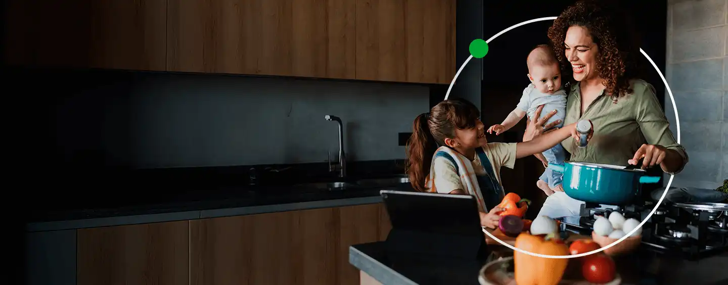 Mãe e filha cozinhando juntas na cozinha, enquanto a filha segura um bebê, criando um momento de carinho e aprendizado na cozinha.