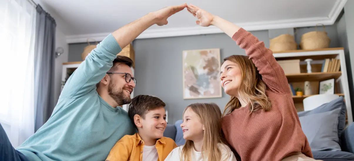 família de 4 pessoas onde o pai e a mãe estão protegendo os filhos com as mãos