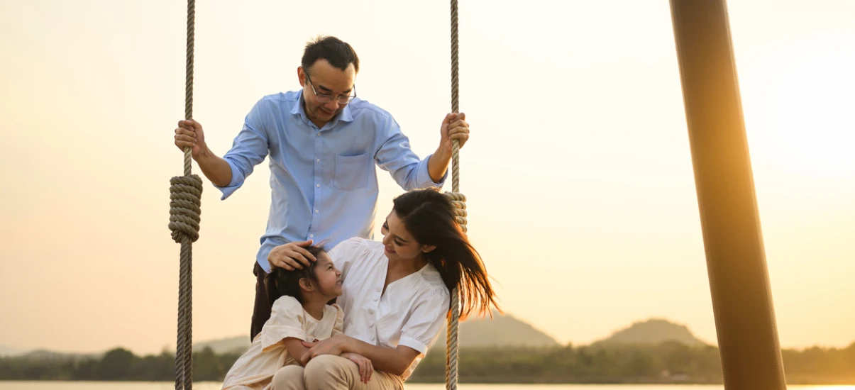 família feliz balançando ao por do sol