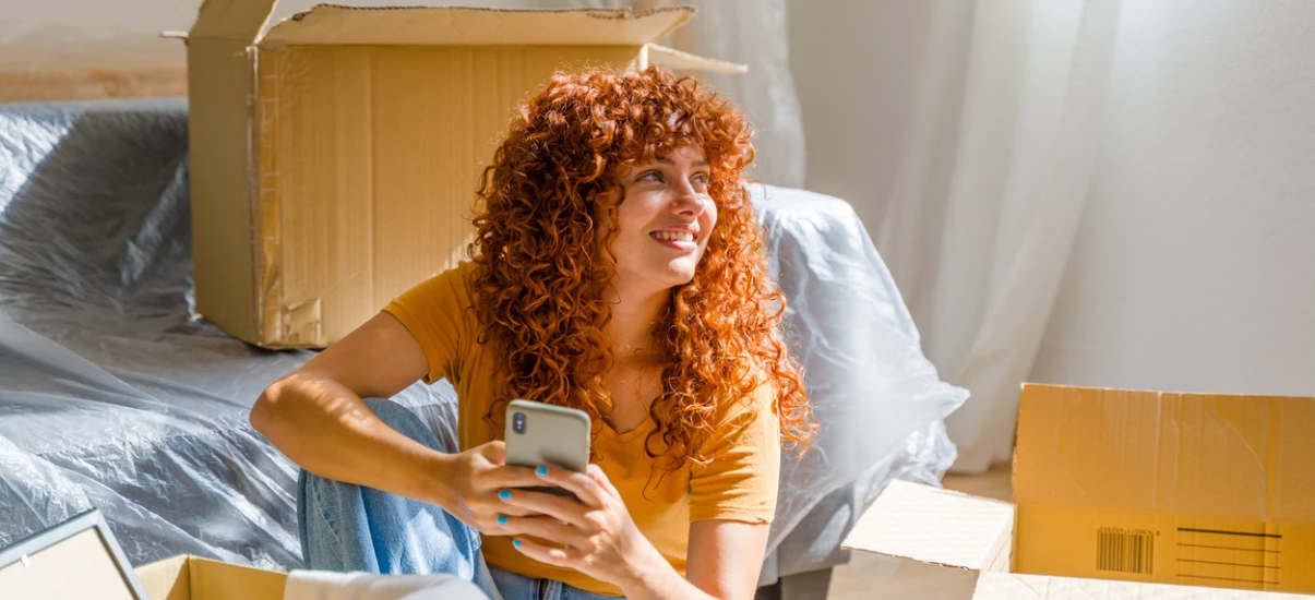 mulher-sorrindo-com-celular-em-mudança